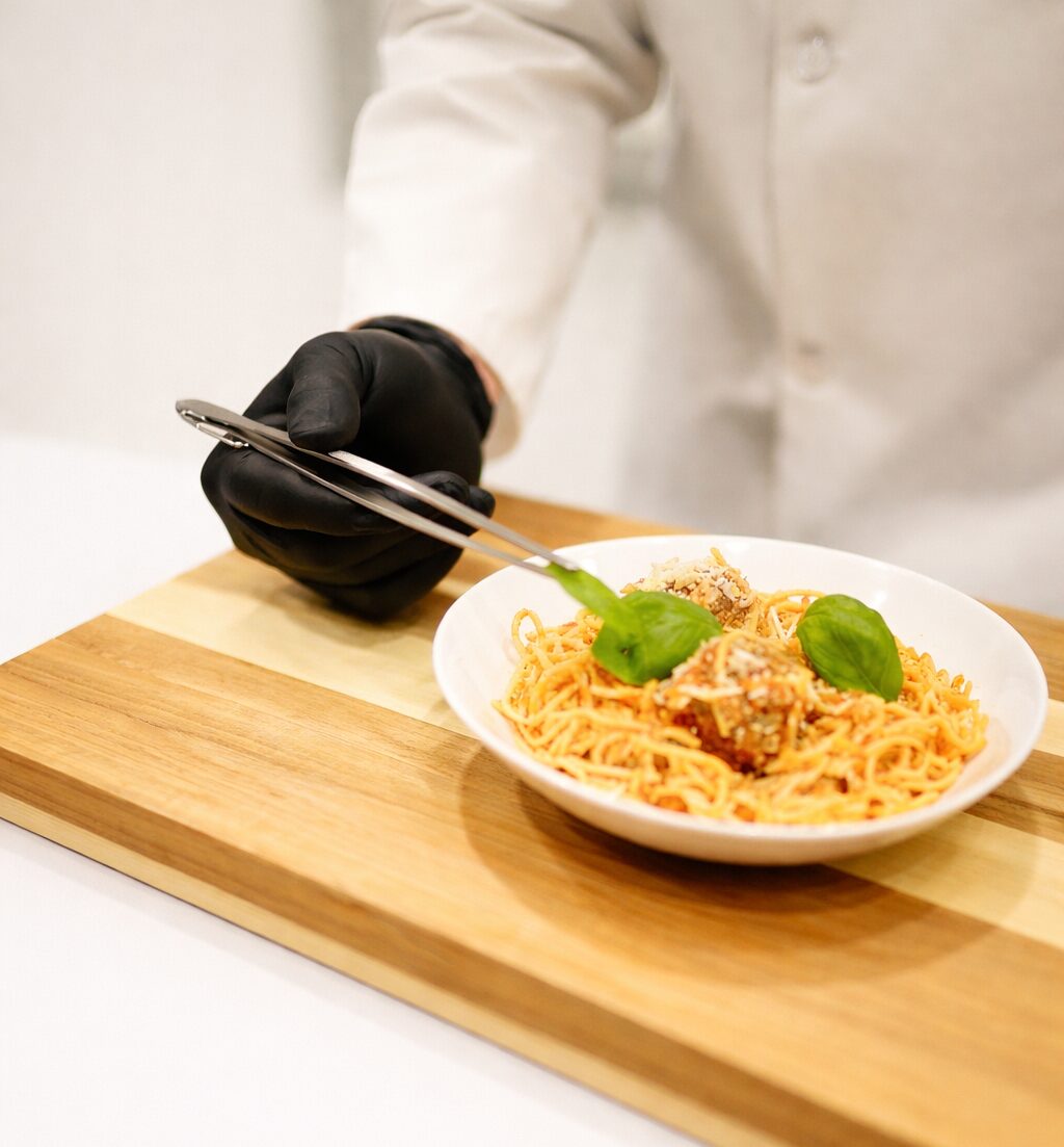 Chef-adjusting-basil-on-spaghetti-1
